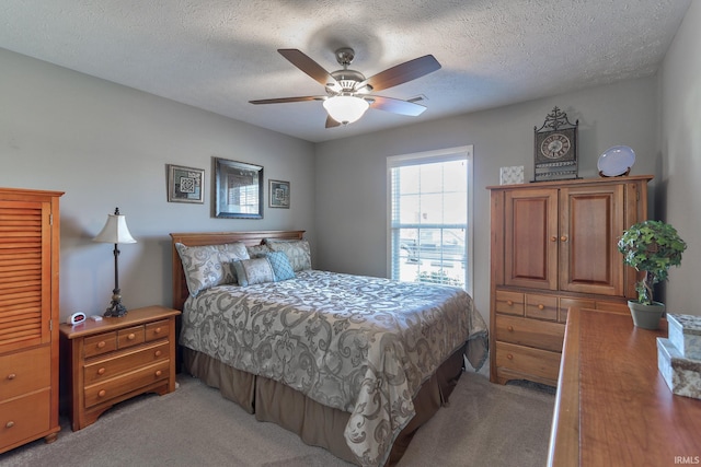 carpeted bedroom with ceiling fan and a textured ceiling