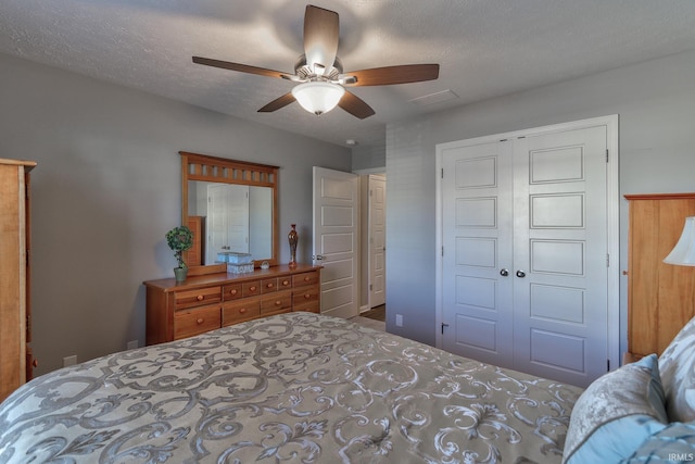 bedroom with ceiling fan, a closet, and a textured ceiling