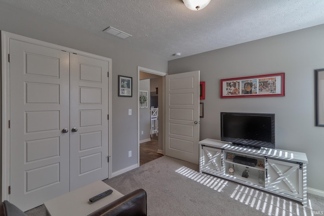 living room featuring light carpet and a textured ceiling