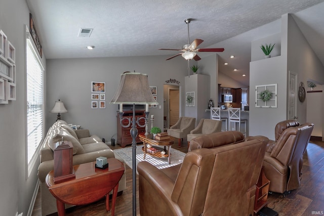 living room with ceiling fan, dark hardwood / wood-style floors, high vaulted ceiling, and a textured ceiling