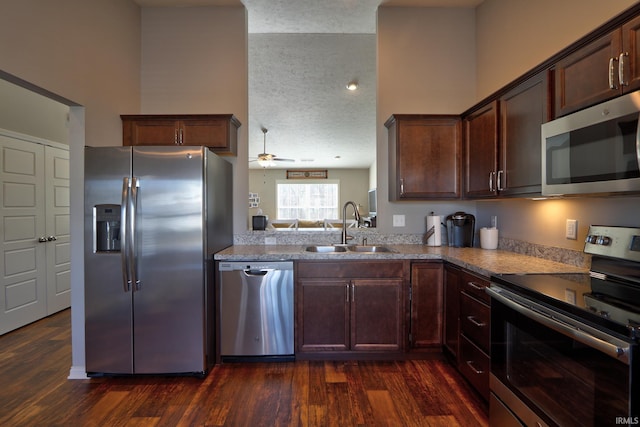 kitchen featuring dark wood-type flooring, sink, a textured ceiling, appliances with stainless steel finishes, and ceiling fan