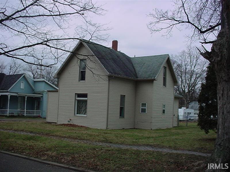 view of property exterior with a lawn and a porch