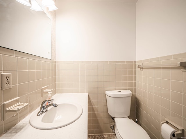 bathroom featuring vanity, toilet, and tile walls