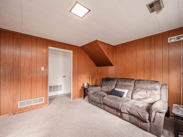 carpeted living room featuring wooden walls