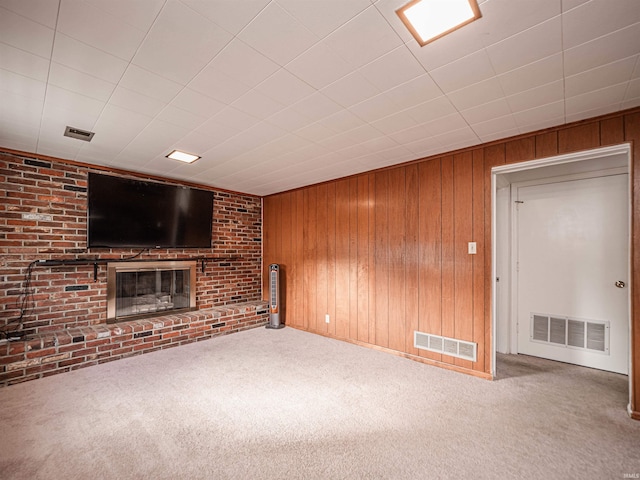 unfurnished living room with wood walls and carpet flooring