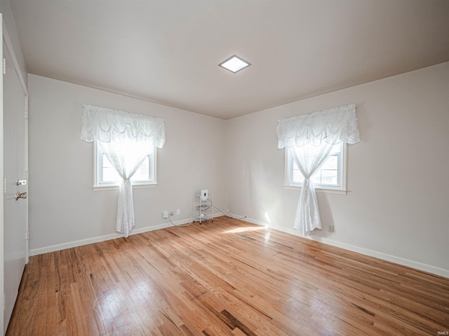 unfurnished room featuring wood-type flooring and a healthy amount of sunlight