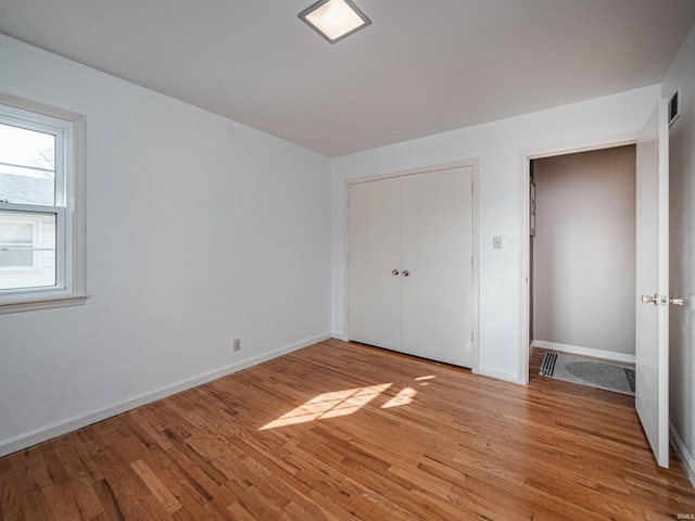 unfurnished bedroom featuring light hardwood / wood-style flooring and a closet