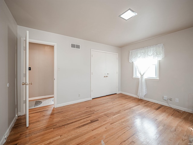 unfurnished bedroom featuring a closet and light hardwood / wood-style flooring