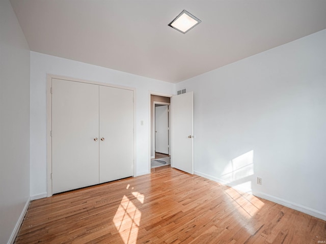 unfurnished bedroom featuring a closet and light hardwood / wood-style flooring