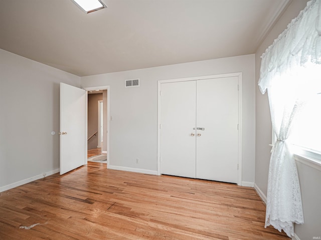 unfurnished bedroom with light hardwood / wood-style floors and a closet