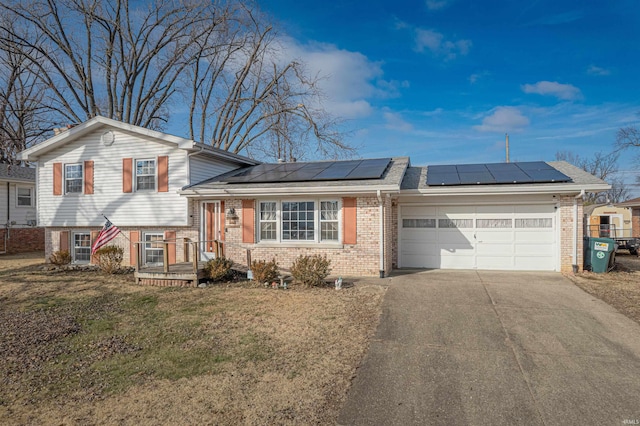 view of front of home featuring a garage, a front lawn, and solar panels