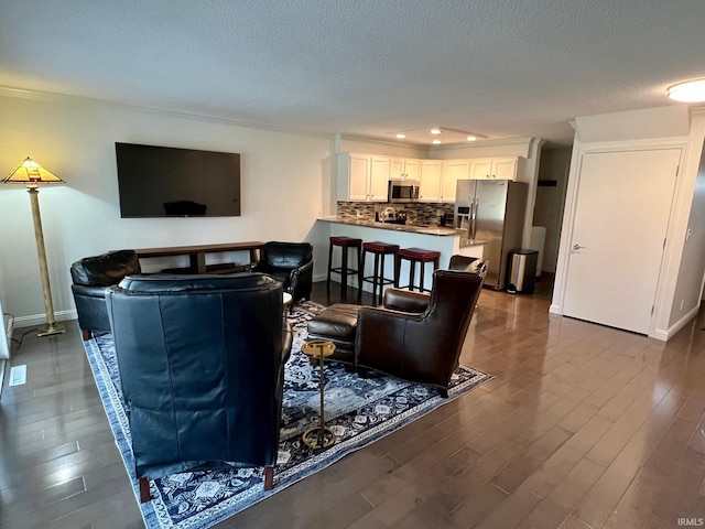 living room with a textured ceiling and dark hardwood / wood-style flooring