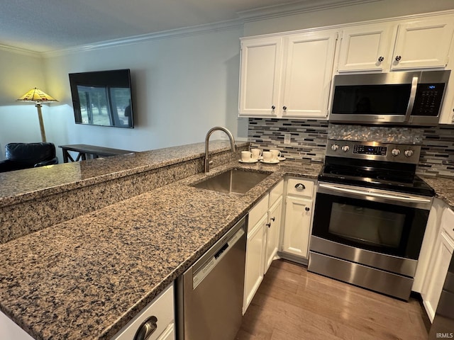 kitchen featuring white cabinetry, stainless steel appliances, kitchen peninsula, and sink