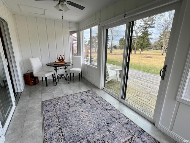 unfurnished sunroom featuring ceiling fan