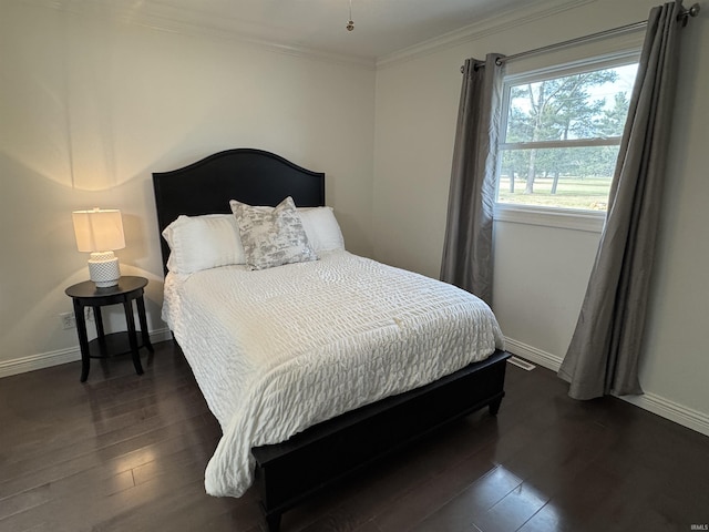 bedroom featuring ornamental molding and dark hardwood / wood-style flooring