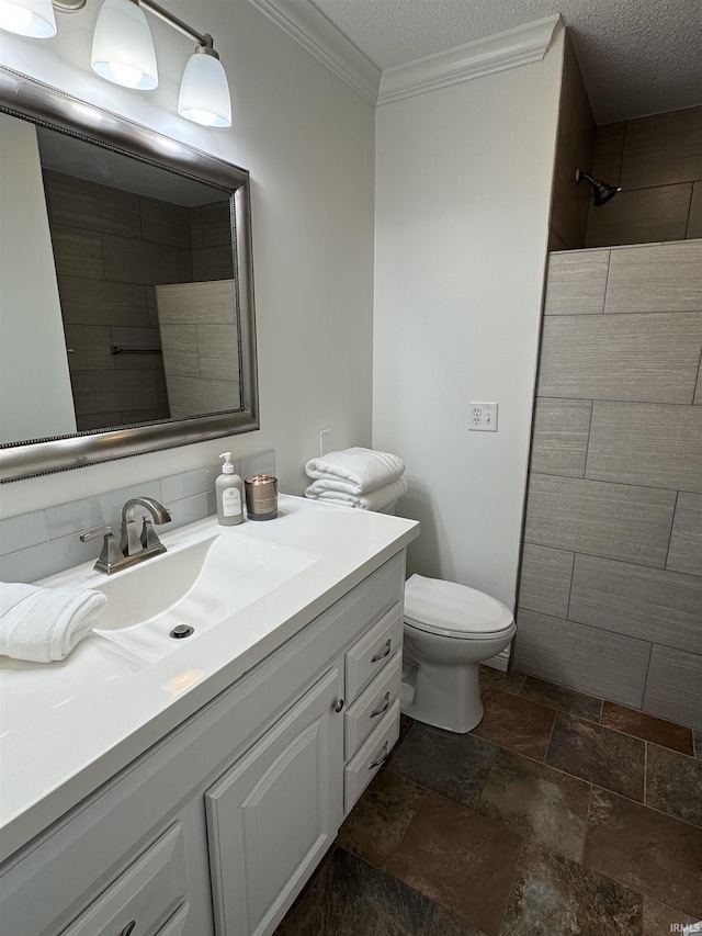 bathroom featuring vanity, tiled shower, toilet, crown molding, and a textured ceiling