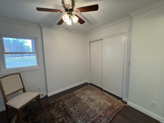 unfurnished bedroom featuring a textured ceiling, ornamental molding, dark hardwood / wood-style floors, a closet, and ceiling fan