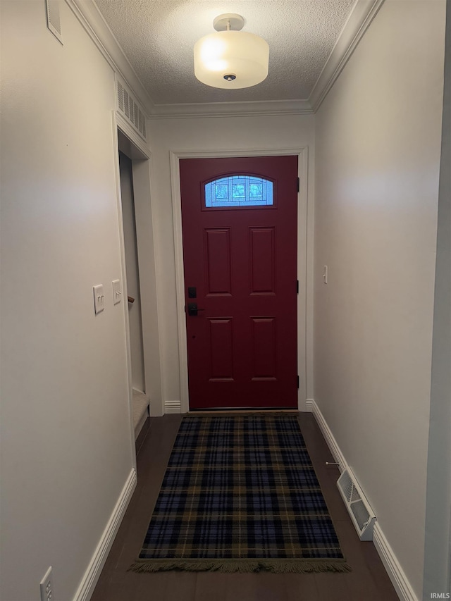 doorway featuring ornamental molding and a textured ceiling