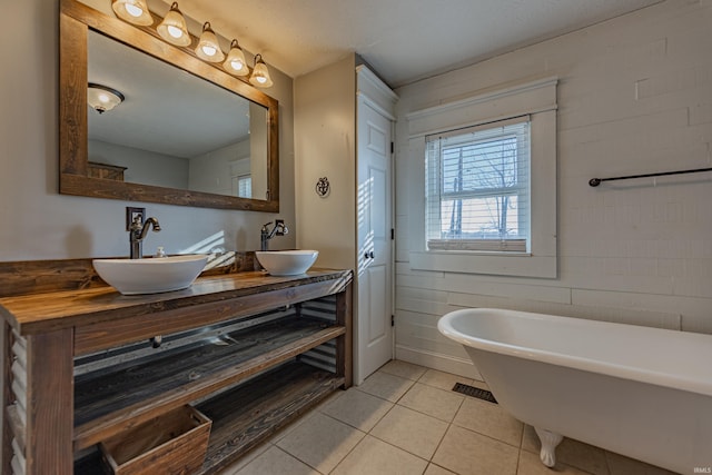 bathroom featuring tile patterned flooring, a bath, and vanity