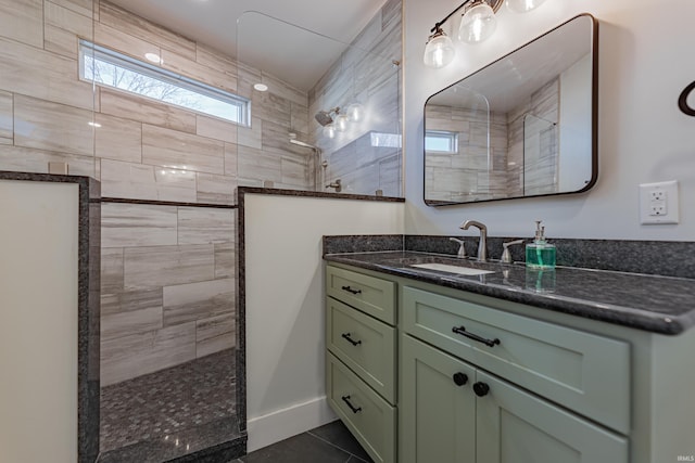 bathroom with vanity, tile patterned flooring, and a tile shower