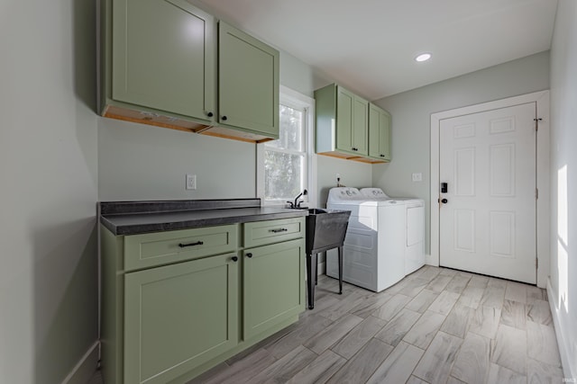 washroom with washer and clothes dryer, cabinets, and light wood-type flooring