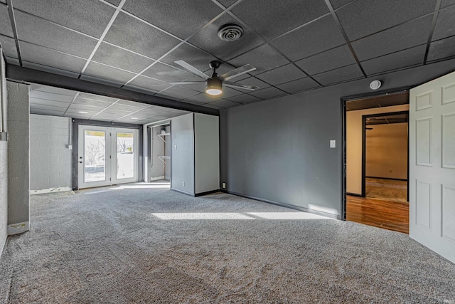 carpeted spare room featuring a paneled ceiling and ceiling fan