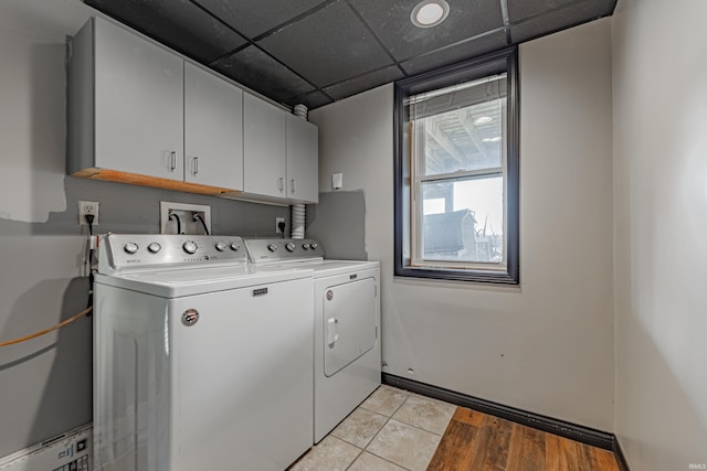 laundry room with independent washer and dryer, cabinets, and light tile patterned floors