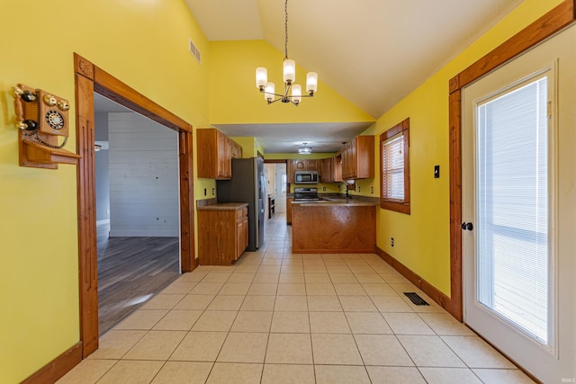 kitchen with light tile patterned flooring, sink, decorative light fixtures, a notable chandelier, and stainless steel appliances