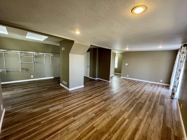 unfurnished living room with dark hardwood / wood-style floors and a textured ceiling