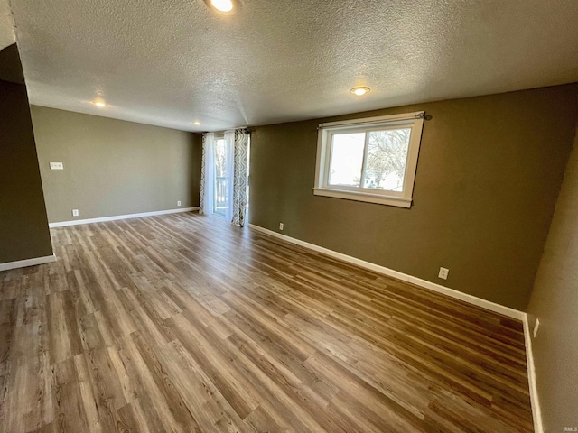 spare room featuring hardwood / wood-style flooring and a textured ceiling