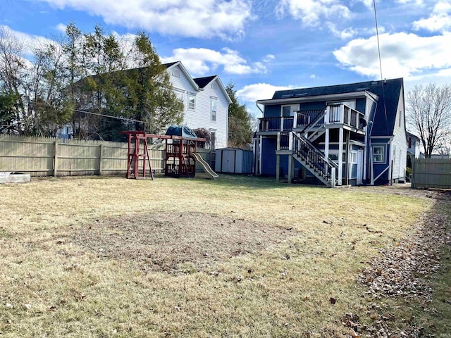 view of yard with a shed, a wooden deck, and a playground