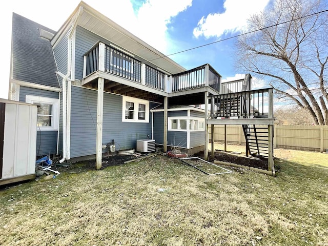 back of house featuring cooling unit, a deck, and a lawn