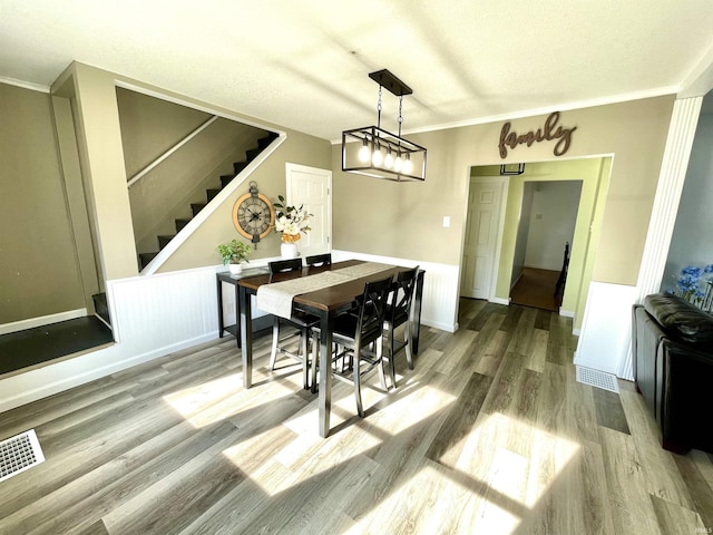 dining room with hardwood / wood-style flooring and ornamental molding