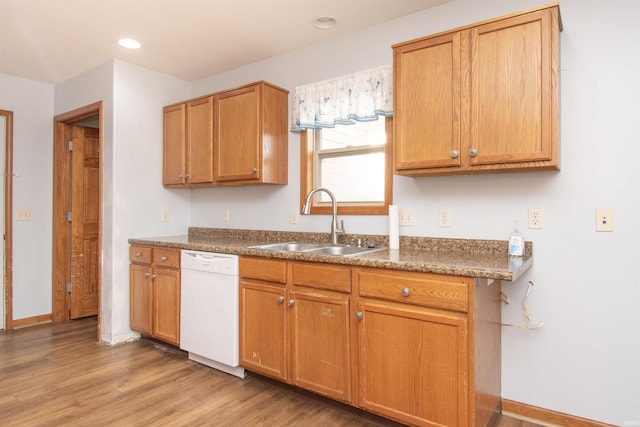 kitchen with dishwasher, sink, and light wood-type flooring