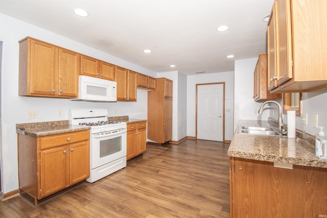 kitchen featuring hardwood / wood-style flooring, white appliances, and sink