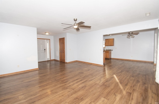 unfurnished living room featuring ceiling fan and dark hardwood / wood-style flooring