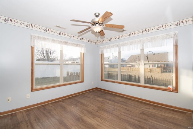 empty room featuring dark wood-type flooring and ceiling fan