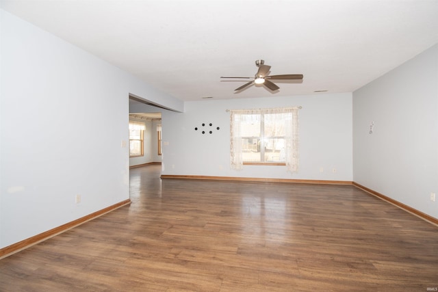 spare room with dark wood-type flooring and ceiling fan