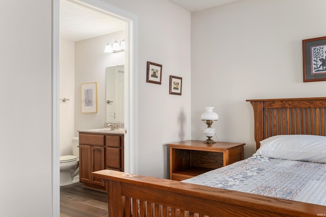 bedroom featuring connected bathroom, sink, and hardwood / wood-style floors