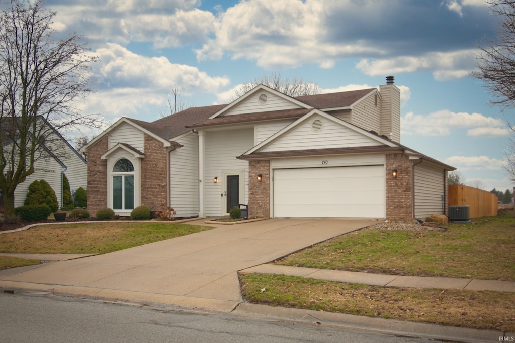 view of front of house with central AC unit and a front yard