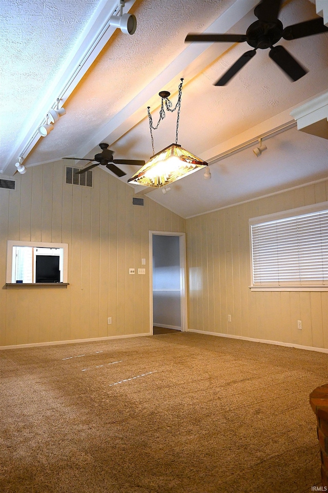 spare room featuring ceiling fan, vaulted ceiling with beams, carpet flooring, track lighting, and a textured ceiling