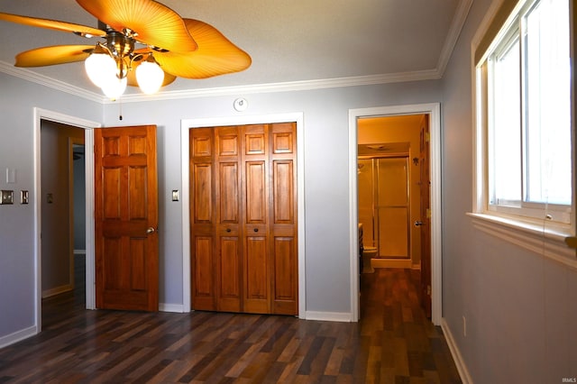 unfurnished bedroom featuring crown molding, ceiling fan, dark hardwood / wood-style floors, and a closet