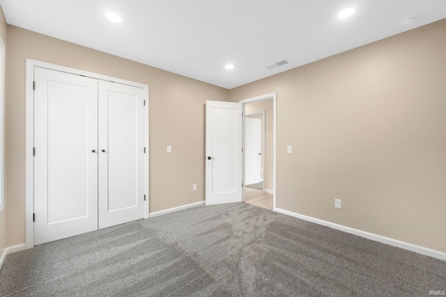 unfurnished bedroom featuring carpet flooring and a closet