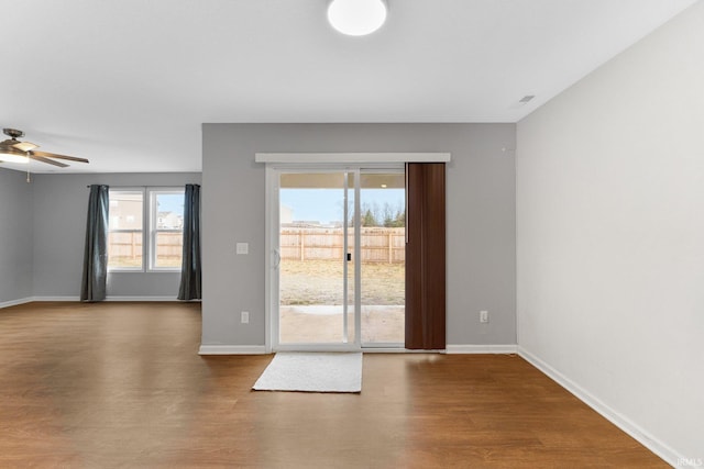 unfurnished room with a wealth of natural light, hardwood / wood-style floors, and ceiling fan