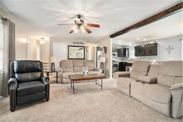 living room featuring ceiling fan, beam ceiling, sink, and light carpet