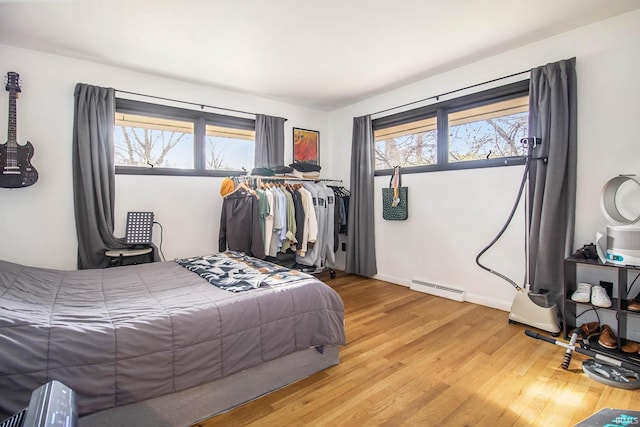 bedroom featuring a baseboard radiator and light hardwood / wood-style floors