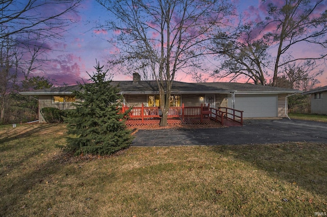 view of front of property with a garage, a yard, and covered porch