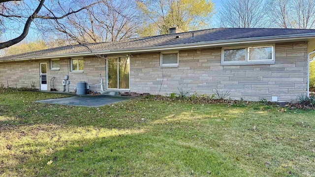 rear view of property featuring a lawn and a patio area