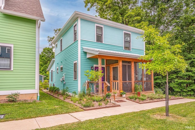 view of front of home featuring a front lawn and a sunroom