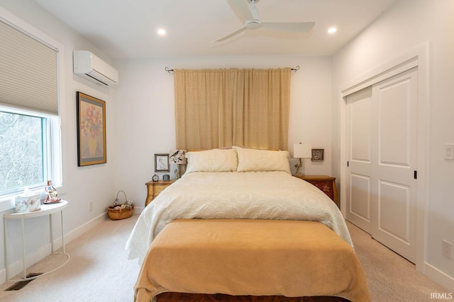 carpeted bedroom with ceiling fan, a closet, and a wall unit AC